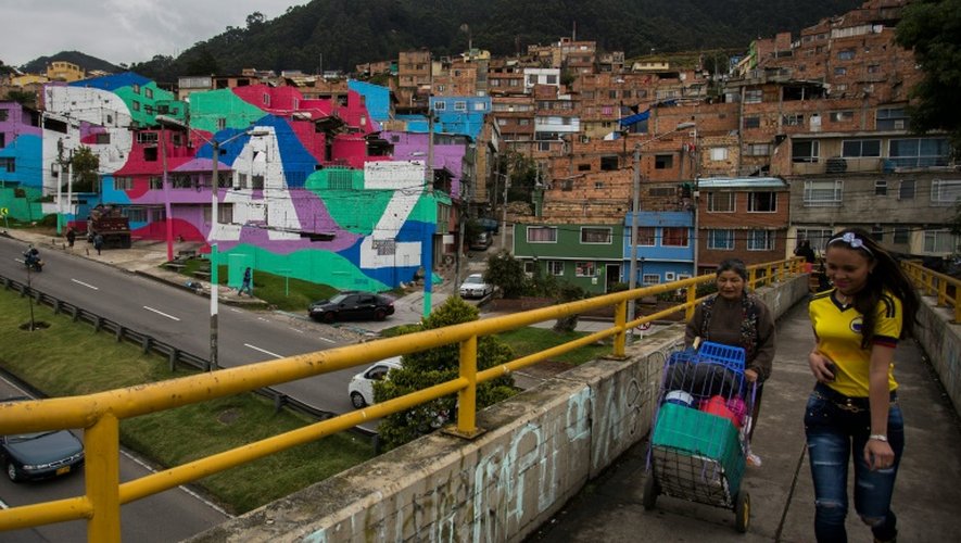 Des habitants du quartier pauvre de Mariscal Sucre empruntent la passerelle qui surplombe l'avenue reliant le centre de Bogota aux quartiers riches du nord de la capitale, le 1er septembre 2016
