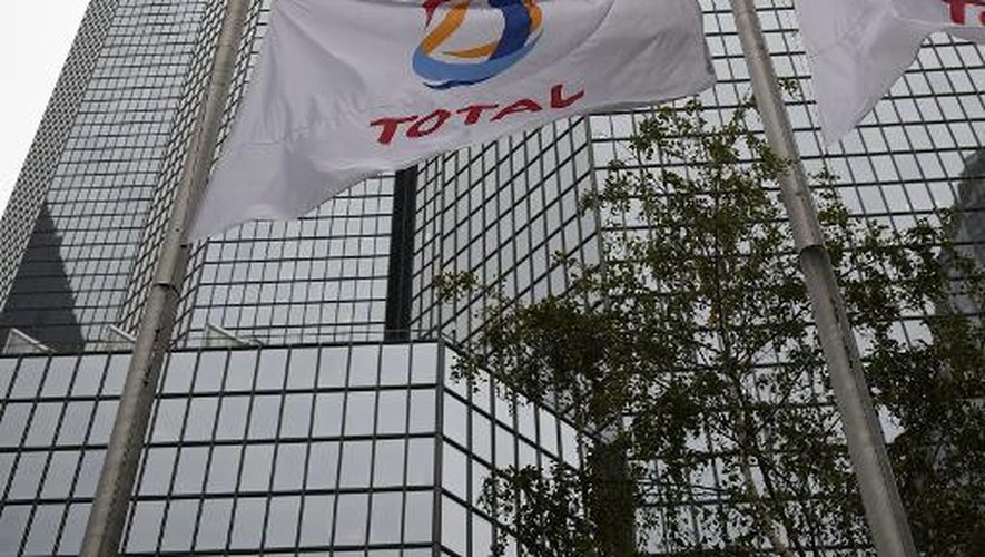 Drapeaux en berne devant le siège du groupe pétrolier Total, dans le quartier d'affaires de la Défense près de Paris, le 21 octobre 2014
