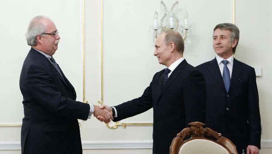 Le PDG de Total, Christophe de Margerie (g), serre la main de Vladimir Poutine, sous le regard du PDG de Novatek, Leonid Mikhelson, le 2 mars 2011 à Moscou
