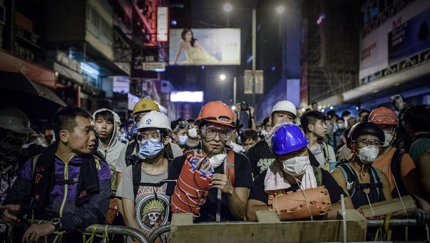 Des manifestants prodémocratie eéquipés de masques, le 19 octobre 2014 sur une barricade dans le quartier Mongkog à Hong Kong