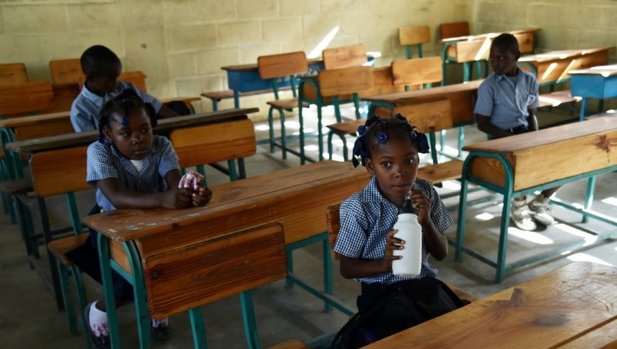 Des élèves sont assis derrière leur bureau le jour de la rentrée à l'école publique de Tabarre, dans la banlieue de Port-au-Prince, le 5 septembre 2016.