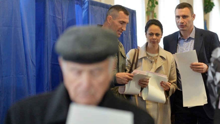 Le maire de Kiev Vitaly Klitschko (D) sa femme Natalia et son frère Vladimir Klitschko votent le 25 octobre 2015 dans la capitale ukrainienne