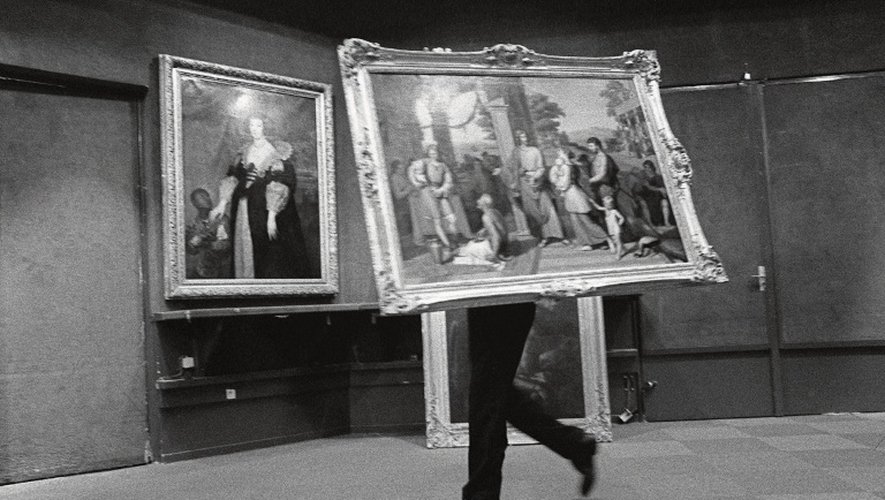 Un commissionnaire, des "Savoyards" ou "cols rouges", de Drouot-Richelieu déplace un tableau avant sa mise en vente, le 5 décembre 2001 dans une salle de cette maison de vente à Paris