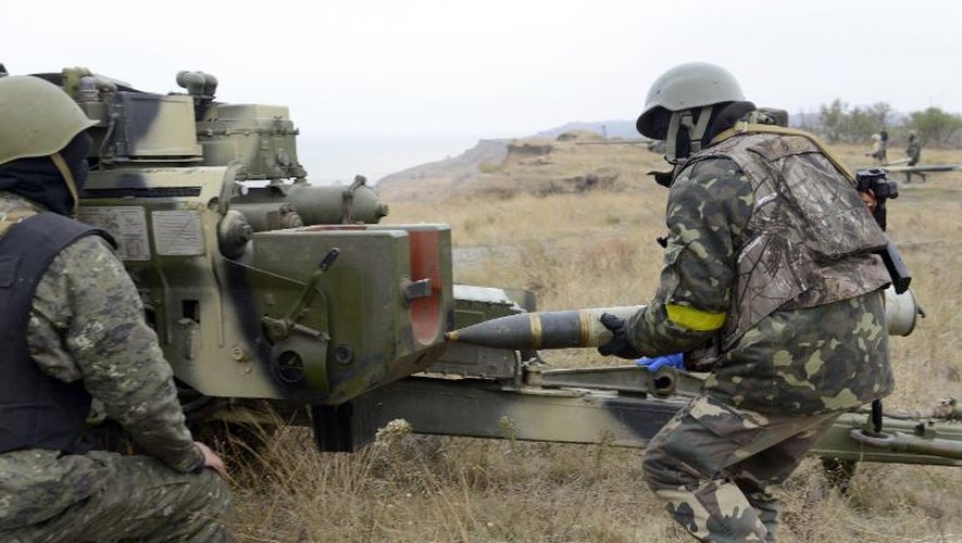 Un soldat ukrainien charge un obus dans un canon d'artillerie près de Marioupol