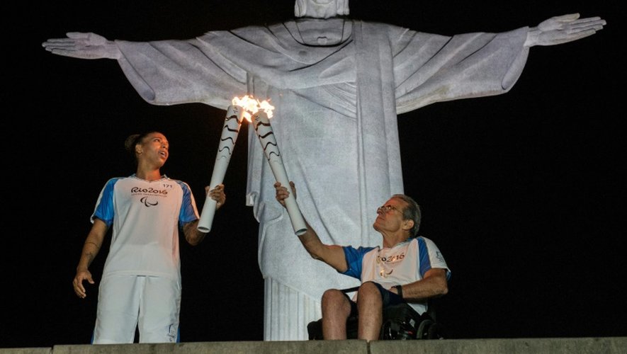 Passage de relais de la torche olympique entre Thomas Magalhaes (D) et la judoka brésilienne Rafaela Silva, pour les Jeux Paralympiques le 6 septembre 2016 à Rio