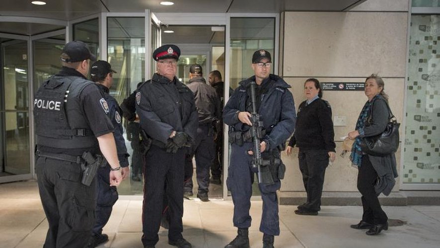 Des policiers armés devant l'entrée d'un bâtiment après une fusillade au Parlement d'Ottawa, le 22 octobre 2014 au Canada