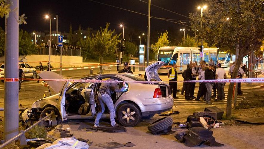 Des policiers israéliens inspectent une voiture qui a été lancée par un Palestinien sur un groupe de piétons, le 22 octobre 2014 à Jérusalem