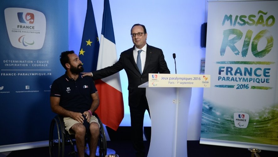 Le porte drapeau de la délégation française aux Jeux paralympiques à Rio, Michael Jeremiasz (g) lors du discours du président François Hollande (d), le 1er septembre 2016 à Paris