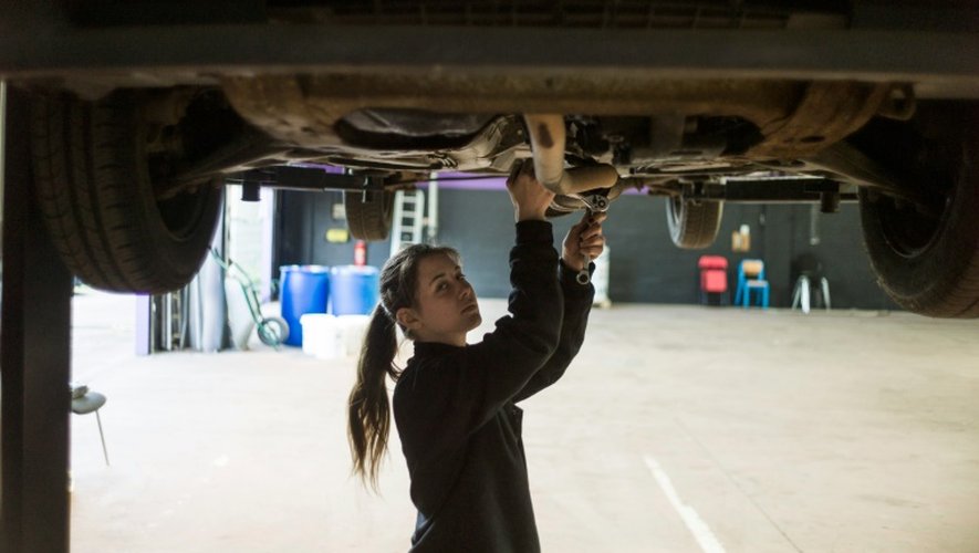 Une femme mécanicienne répare une voiture le 14 mai 2014 à Saint-Ouen-l'Aumone.