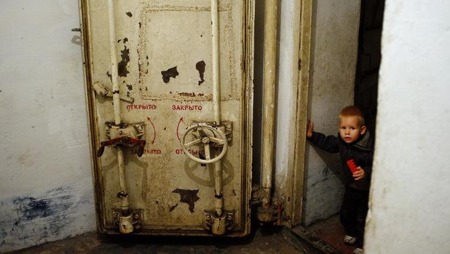 Un petit garçon sort le 23 octobre 2014 d'un abri où une centaine de personnes sont réfugiées à Donetsk où les combats font rage entre rebelles prorusses et forces ukrainiennes