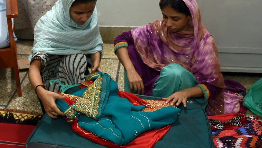 La jeune Indienne Geeta, sourde et muette, aidée par une amie, prépare ses valises qu'elle remplit de cadeaux et de vêtements pour ses proches avant son départ en Inde, le 22 octobre 2015 à la fondation Edhi à Karachi, au Pakistan