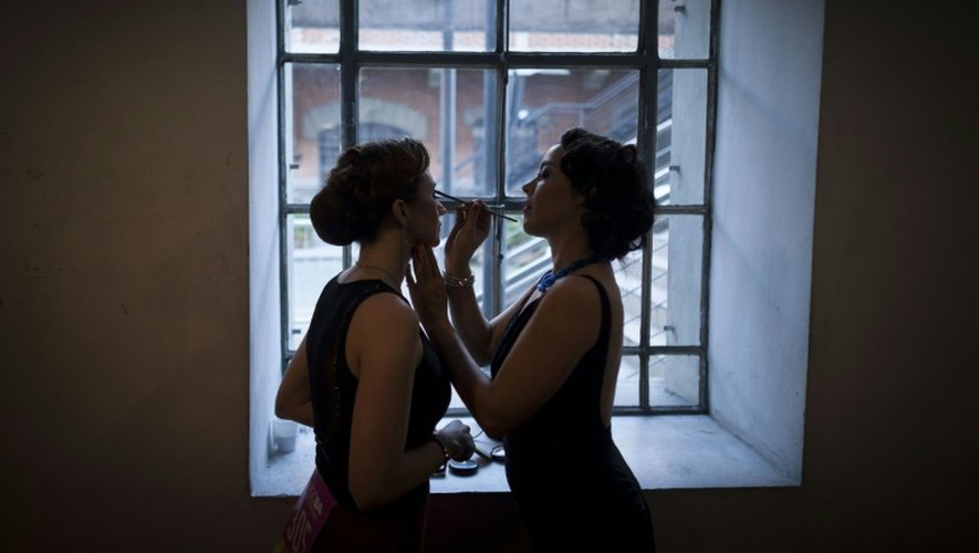 La danseuse de tango argentine Yuko Artak (d) maquille sa partenaire de danse Liliana Chenlo avant une représentation de tango queer à Buenos Aires, lors d'une compétition mondiale, le 23 août 2016