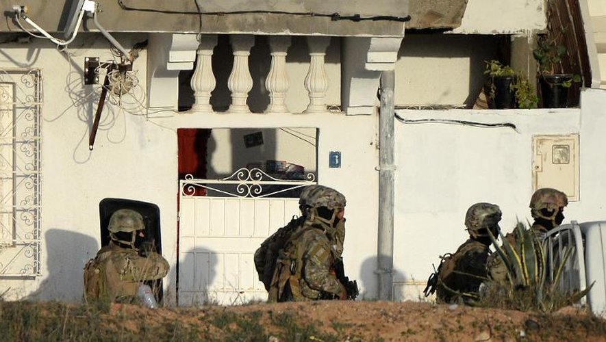 Les forces de sécurité tunisiennes encerclent une maison où sont retranchés des hommes armés avec des femmes et des enfants, avant de donner l'assaut, le 24 octobre 2014 à Oued Ellil, dans la banlieue de Tunis