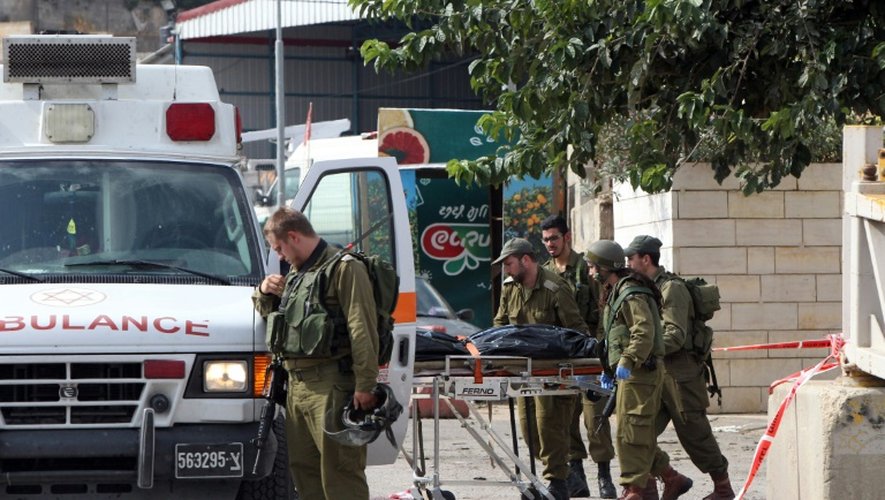 Des soldats israéliens évacuent le corps du Palestinien Raed Jarradat, qui a blessé un israélien avant d'être tué par balles, le 26 octobre 2015