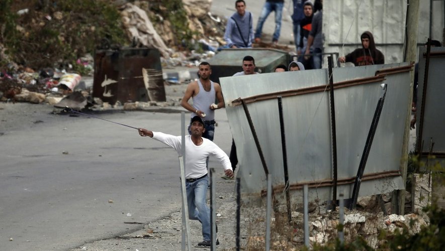 Des manifestants palestiniens jettent des pierres sur des soldats israéliens, dans le village de Sair, près d'Hébron en Cisjordanie, le 26 octobre 2015