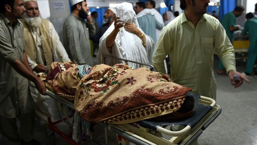 Une personne blessée pendant le séisme est accompagnée par ses proches à l'hôpital de Peshawar, le 26 octobre 2015 au Pakistan
