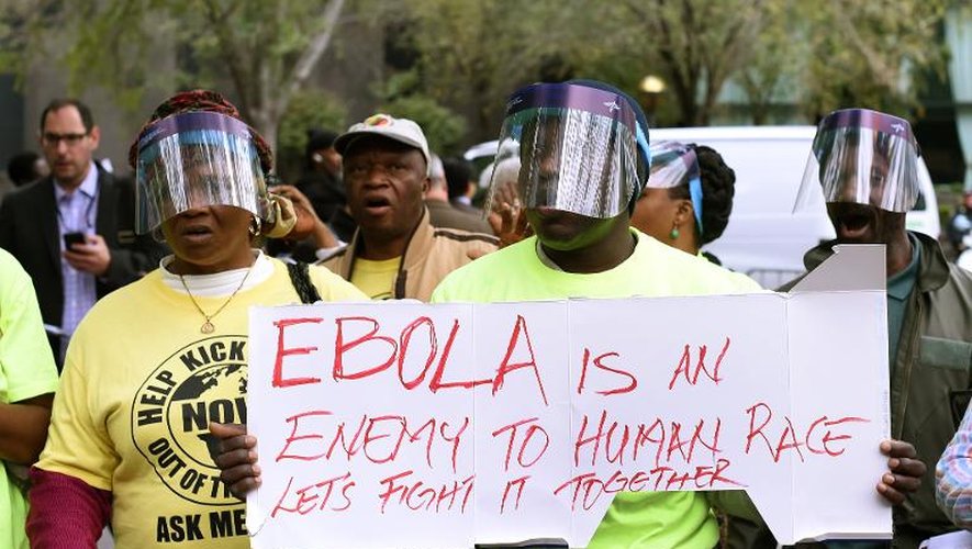 Des manifestants sont rassemblés à New York, le 24 octobre 2014, brandissant une pancarte "Ebola est l'ennemi de la race humaine"