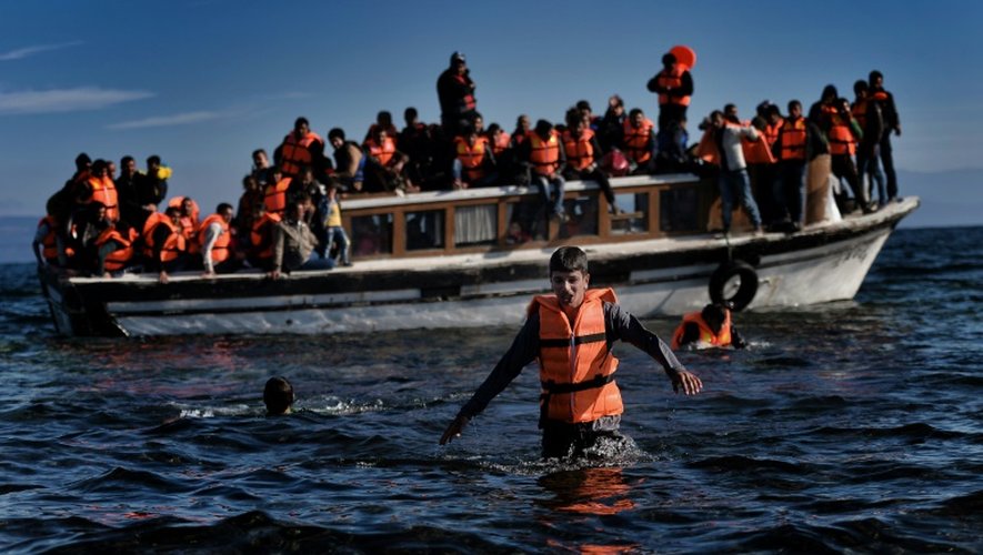 Des migrants et réfugiés arrivent en bateau sur l'île grecque de Lesbos, le 26 octobre 2015 après avoir traversé la mer Egée depuis la Turquie