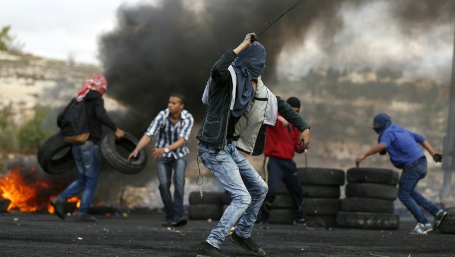 Des manifestants palestiniens, lors d'affrontements avec les forces de sécurité israéliennes au nord d'Al-Bireh, près de Ramallah en Cisjordanie, le 27 octobre 2015