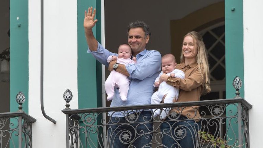Aecio Neves avec sa femme et ses filles jumelles au balcon du domicile de sa mère le 25 octobre 2014 à Sao Joao del Rei