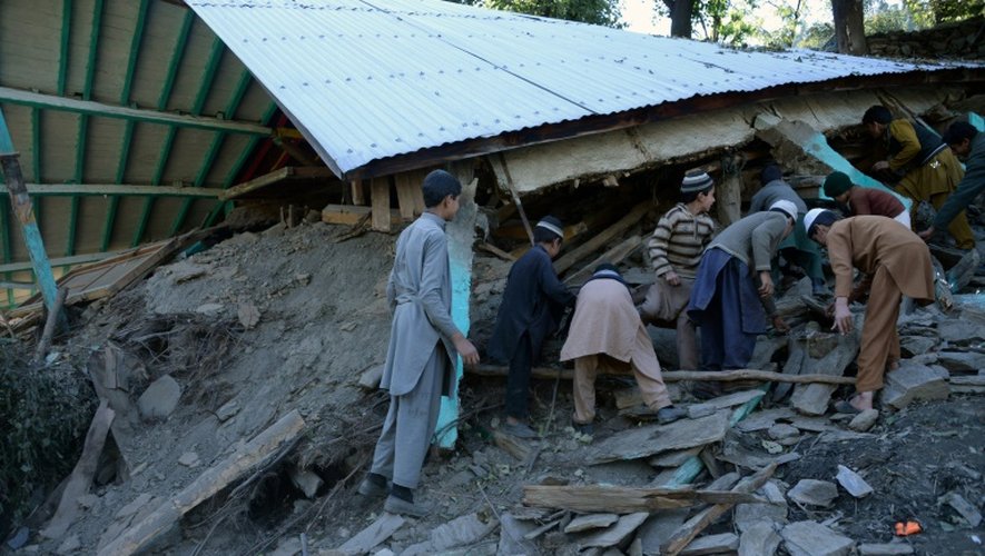 Des habitants fouillent les décombres de maisons à la recherche de victimes après un puissant séisme, le 27 octobre 2015 à Gandao, au Pakistan