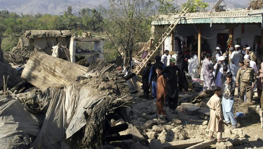 Des policiers et habitants au milieu des ruines de maisons détruites par un puissant séisme, le 27 octobre 2015 à Lower Dir, au Pakistan