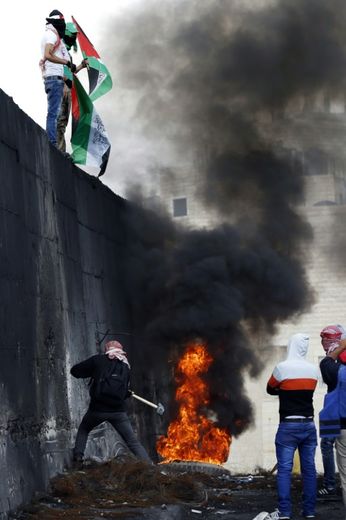 Un Palestinien tente de détruire un bout du mur érigé par Israël entre Jérusalem et la ville d'Abu Dis, en Cisjordanie, le 28 octobre 2015