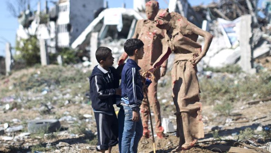 Des enfants palestiniens, le 21 octobre 2014 devant les scuptures réalisées par l'artiste Iyad Sabbah et installées près des ruines laisssées par les  bombardements israéliens à Gaza