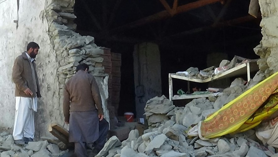 Des habitants de Chitral, dans la province de  Khyber Pakhtunkhwa dans le nord du pays examinent les ruines d'un immeuble, le 27 octobre 2015