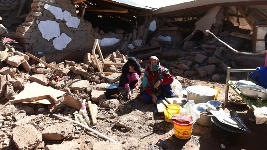 Des survivants du séisme préparent un repas dans les ruines de leur maison à Charun Avir, dans l'extrême-nord du Pakistan le 29 octobre 2015