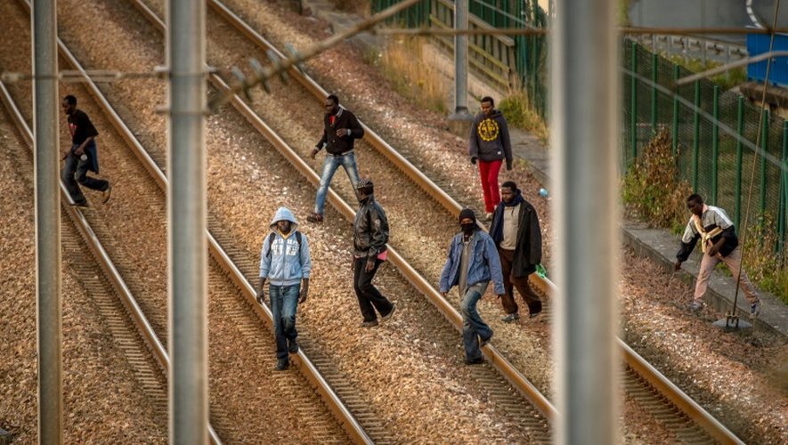 Des migrants sur les rails du site d'Eurotunnel à Coquelles, le 12 août 2015