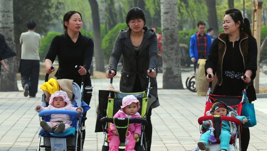 Des femmes avec des enfants en poussette à travers un parc de Pékin, le 5 avril 2011