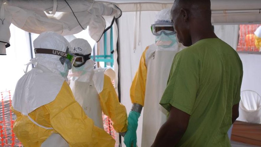 Des travailleurs sanitaires équipés pour soigner les malades du virus Ebola prient dans un centre de traitement de Médecins sans frontières, le 27 octobre 2014 à Monrovia au Libéria