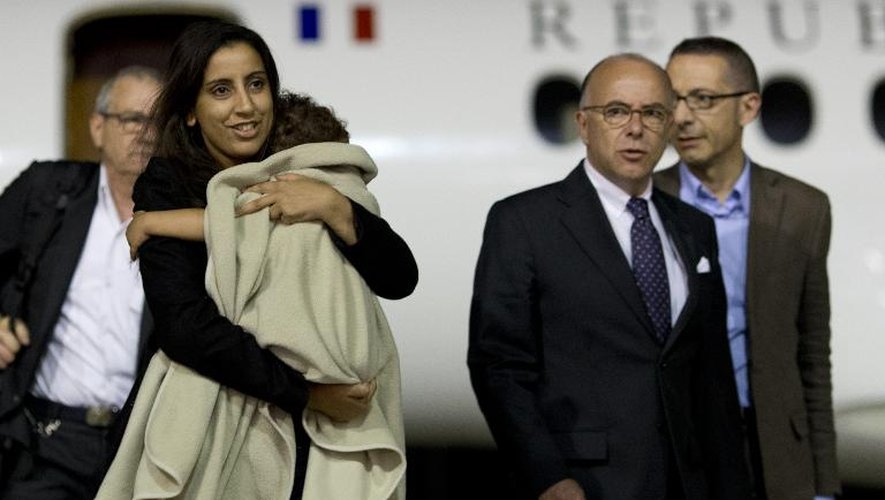 Le ministre de l'Intérieur Bernard Cazeneuve (2e d) accueille Meriam Rhaiem (g) de retour de Turquie avec sa fille Assia le 3 septembre 2014 sur le tarmac de l'aéroport de Vélizy-Villacoublay près de Paris.