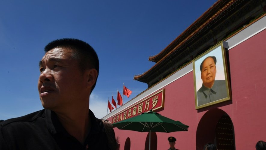 Un homme marche devant le portrait de l'ancien dirigeant chinois Mao Tsé-toung le 9 septembre 2016 sur la place Tiananmen à Pékin