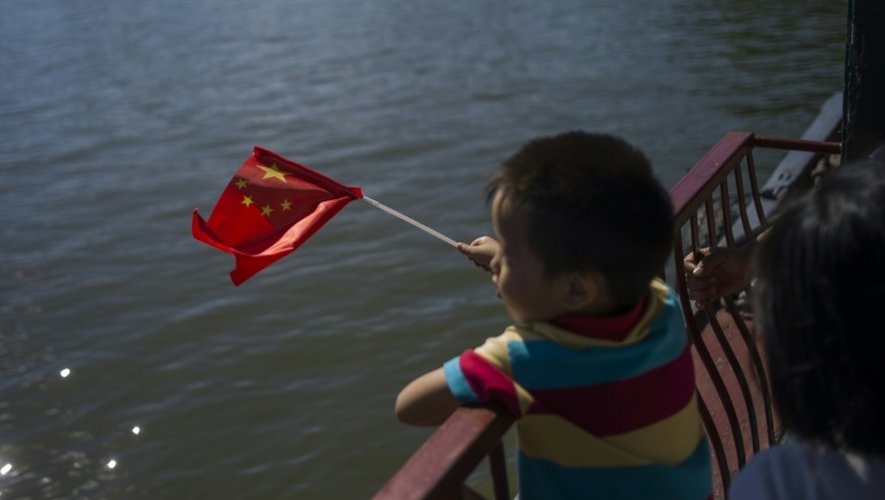 Un enfant tient un drapeau de la République populaire de Chine, en septembre 2015