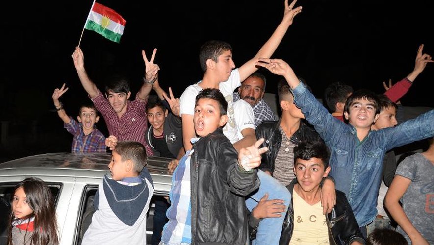 Des Kurdes de Turquie célèbrent l'arrivée des combattants kurdes peshmergas en route, depuis leur base irakienne d'Erbil, pour aller défendre la ville syrienne de Kobané, le 28 octobre 2014