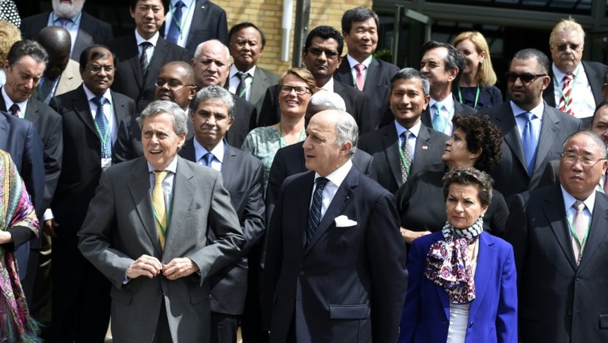 Le ministre français des Affaires étrangères Laurent Fabius au milieu des représentants de délégations lors d'une réunion préparatoire de la COP21 le 21 juillet 2015 à Paris