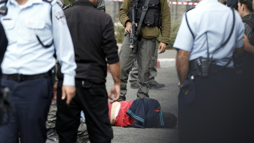 Des forces de sécurité israélienne près d'un Palestinien allongé au sol, après une attaque au couteau, le 30 octobre 2015 à Jérusalem