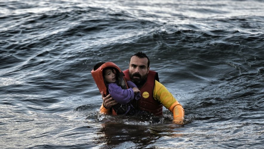 Un garde-côte espagnol porte secours à un enfant qui se trouvait dans une embarcation qui a coulé en mer Egée le 30 octobre 2015 avant d'arriver sur l'île grecque de Lesbos