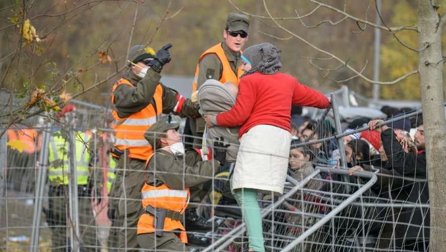 Des militaires autrichiens empêchent une femme tenant son bébé dans les bras de passer un grillage alors qu'elle tente de traverser la frontière austro-slovène depuis Sentilj, en Slovénie, le 30 octobre 2015
