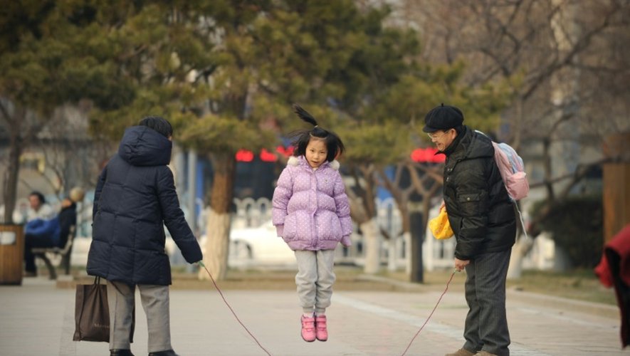 Une petite fille joue à la corde à sauter avec sa famille à Pékin, le 7 décembre 2012