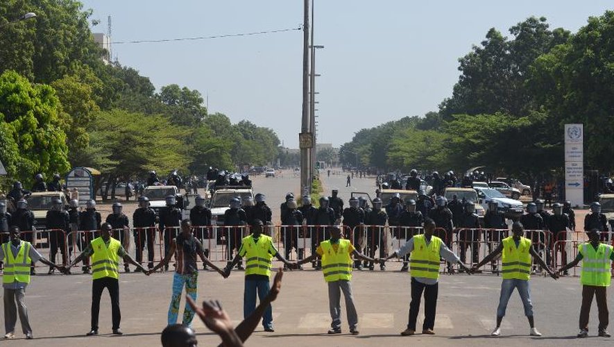 Des policiers devant des manifestants à Ouagadougou pour protéger le passage vers le Parlement, le 29 octobre 2014
