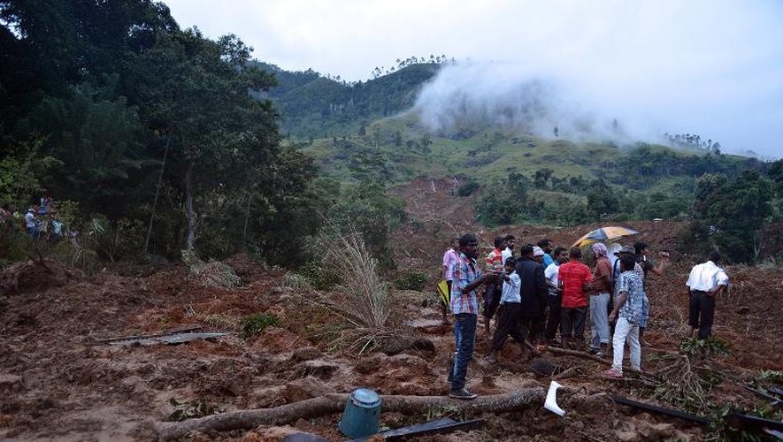 Des habitants de Koslanda sur les lieux d'une coulée de boue provoquée par les pluies de mousson, le 29 octobre 2014 au Sri Lanka