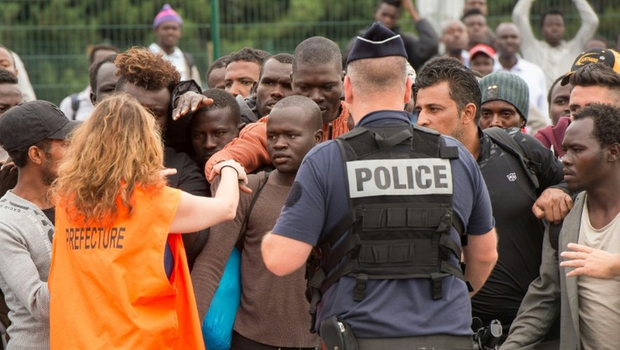 Une chargée de mission de la Préfecture du Nord-Pas-de-Calais sélectionne les migrants qui pourront monter à bord d'un bus à destination d'un Centre d'accueil et d'orientation, le 13 septembre 2016 à Calais