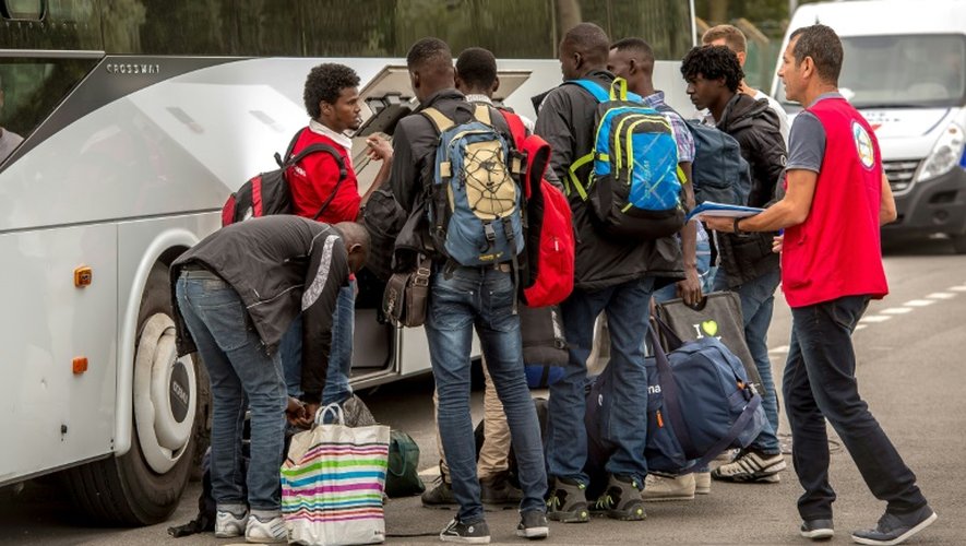 Des migrants de la "jungle" qui ont été sélectionnés s'apprêtent à monter dans un bus à destination d'un Centre d'accueil et d'orientation, le 13 septembre 2016 à Calais