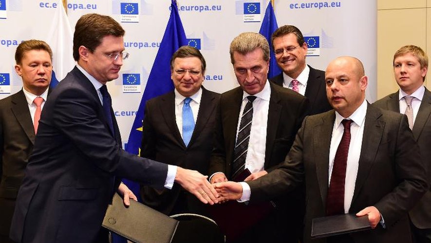 Poignée de mains entre les ministres russe Alexander Novak et ukrainien Yuri Prodan en présence de Jose Manuel Barosso et de Gunther Oettinger le 30 octobre 2014 à Bruxelles