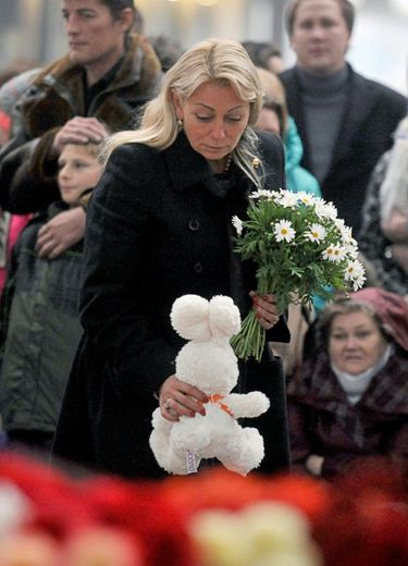 Une femme dépose des fleurs et une peluche en hommage aux victimes à l'aéroport Pulkovo de Saint-Petersbourg le 1er novembre 2015