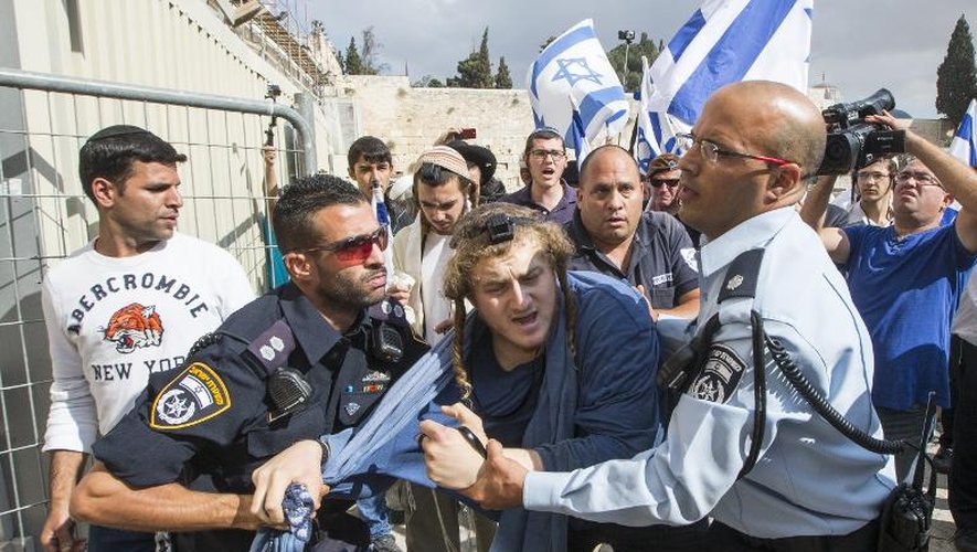 Des policiers israéliens retiennent un militant d'extrême-droite israélien décidé à passer la barrière pour accéder à la Mosquée al-Aqsa, le 30 octobre 2014 à Jérusalem
