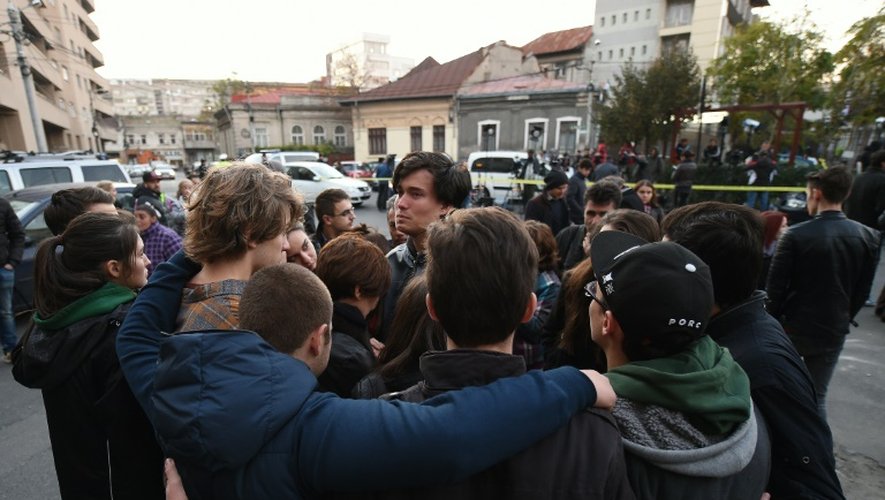 Des jeunes qui ont perdu un proche sont devant la discothèque à Bucarest le 31 octobre 2015 au lendemain de l'incendie qui a fait 27 morts